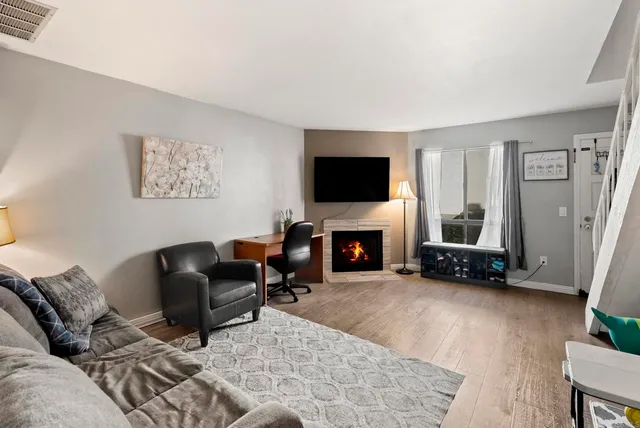 a living room with furniture a fireplace and a flat screen tv