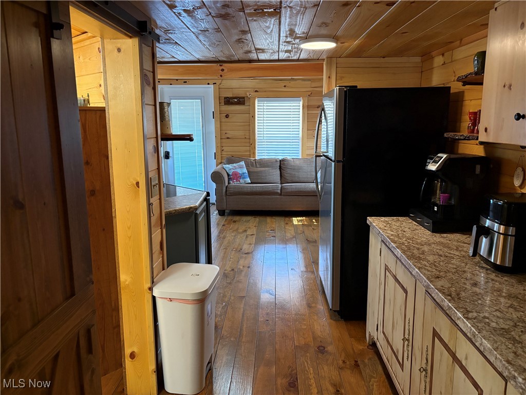 5919 Lake Road West, Unit 13 Ashtabula, OH 44004 - Photo 13 of 35 Kitchen with wood-style floors, wooden walls, wooden ceiling, freestanding refrigerator, and light stone countertops