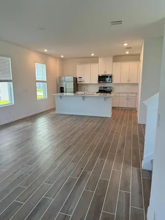 a kitchen with stainless steel appliances a sink stove and white cabinets