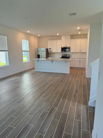 a kitchen with stainless steel appliances a sink stove and white cabinets