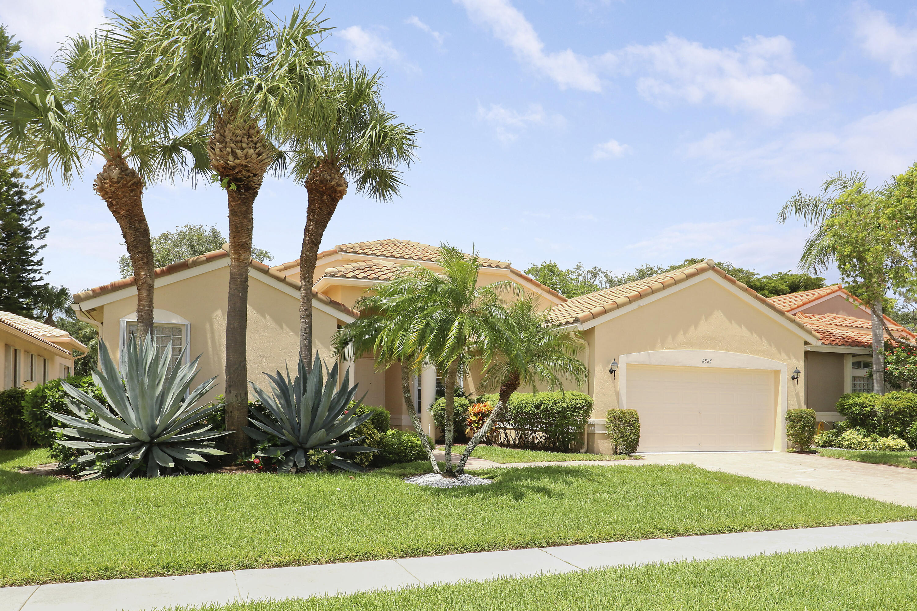 6565 Garde Road Boynton Beach, FL 33472 - Photo 1 of 54 a front view of a house with a garden and trees