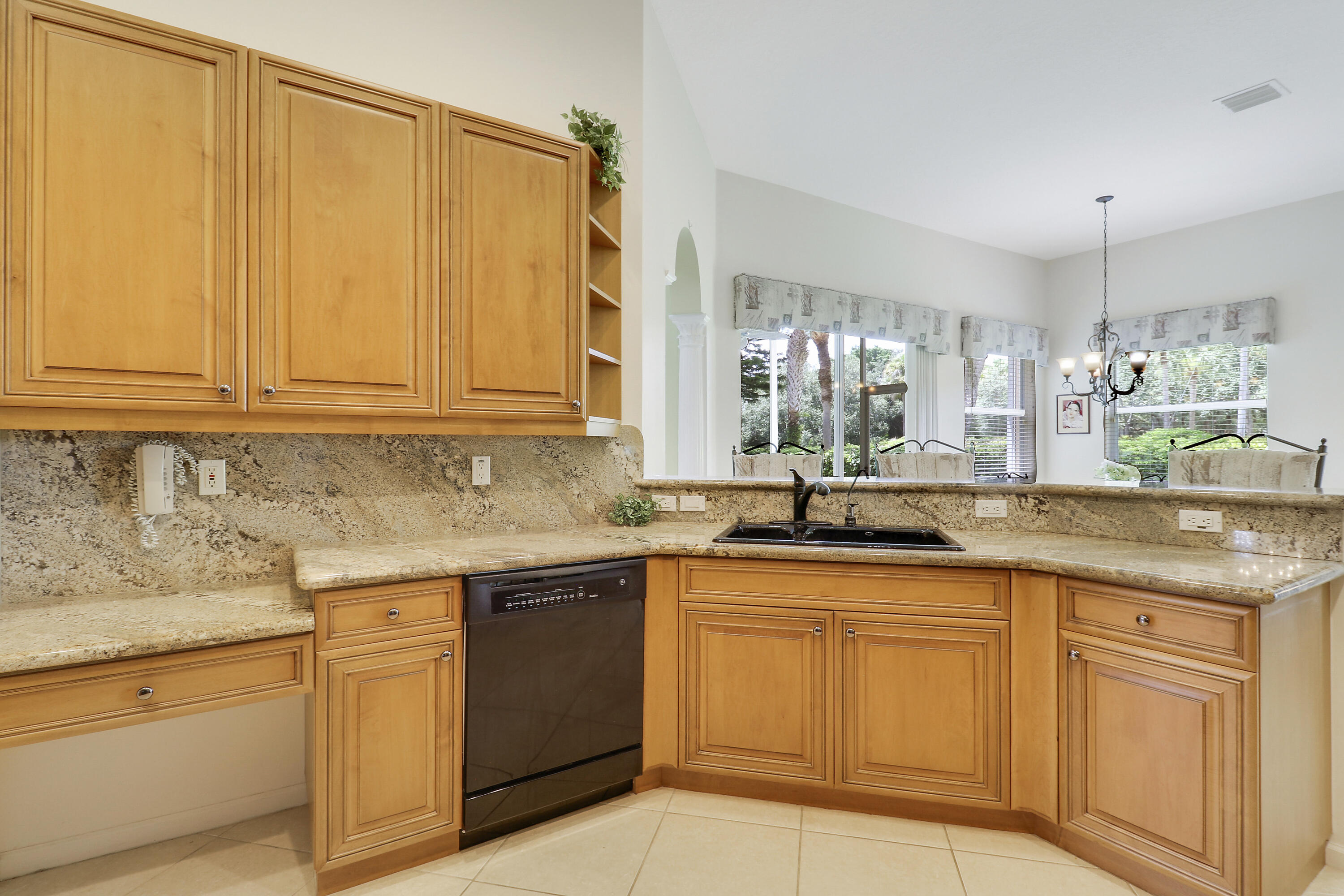 6565 Garde Road Boynton Beach, FL 33472 - Photo 11 of 54 a kitchen with granite countertop sink cabinets and stainless steel appliances