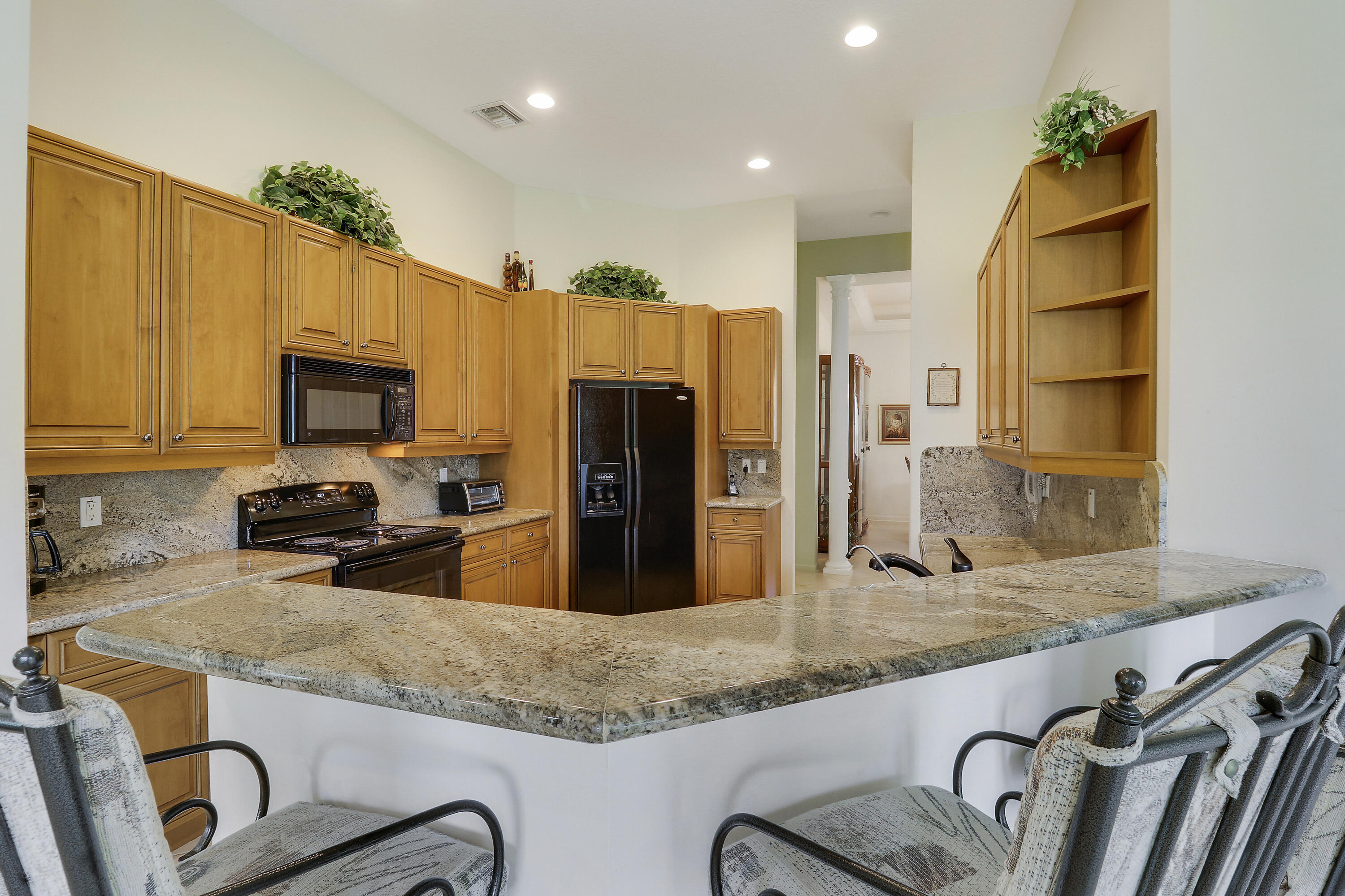 6565 Garde Road Boynton Beach, FL 33472 - Photo 13 of 54 a kitchen with granite countertop a sink a counter top space appliances and cabinets