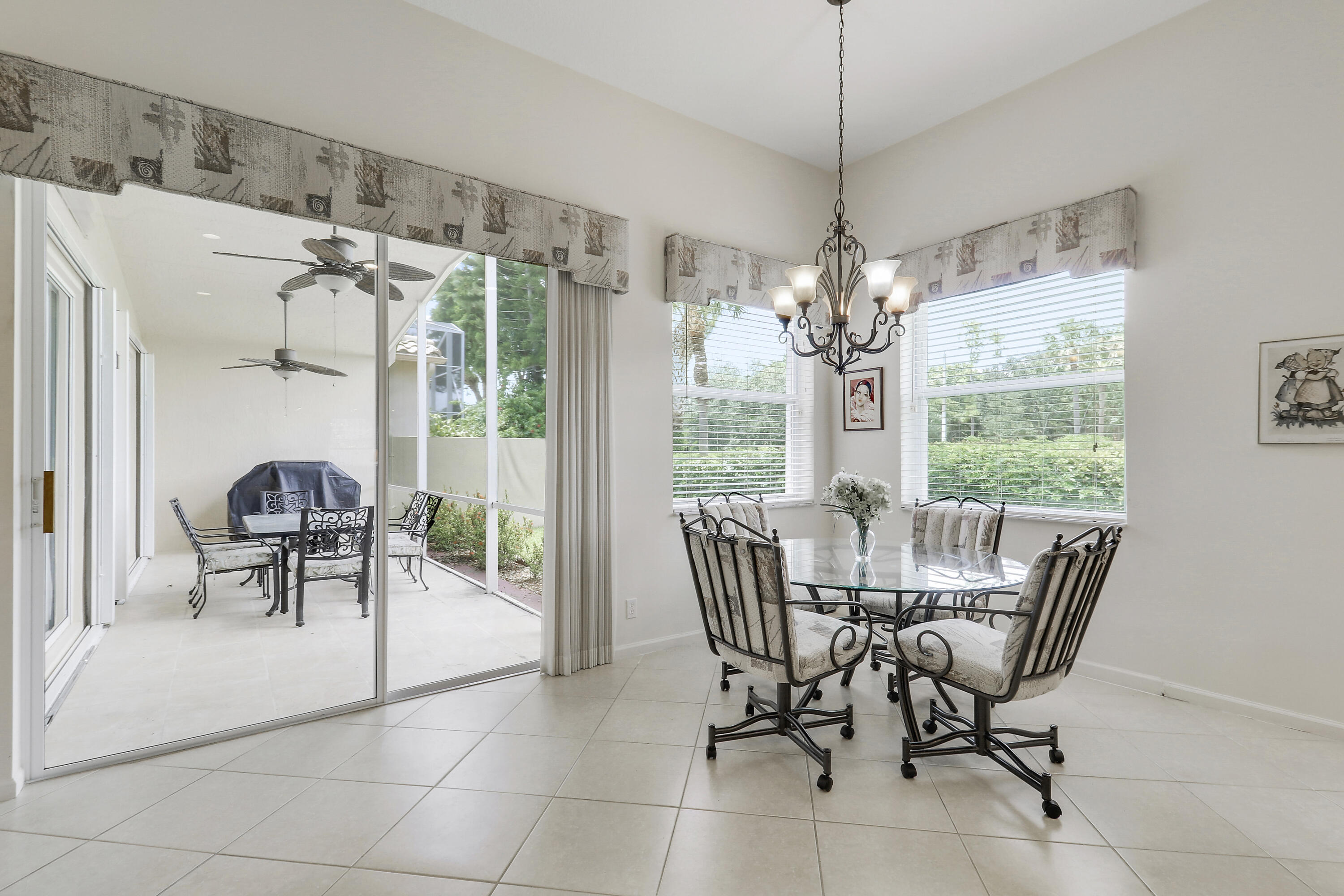 6565 Garde Road Boynton Beach, FL 33472 - Photo 18 of 54 a dining room with furniture a chandelier and a rug