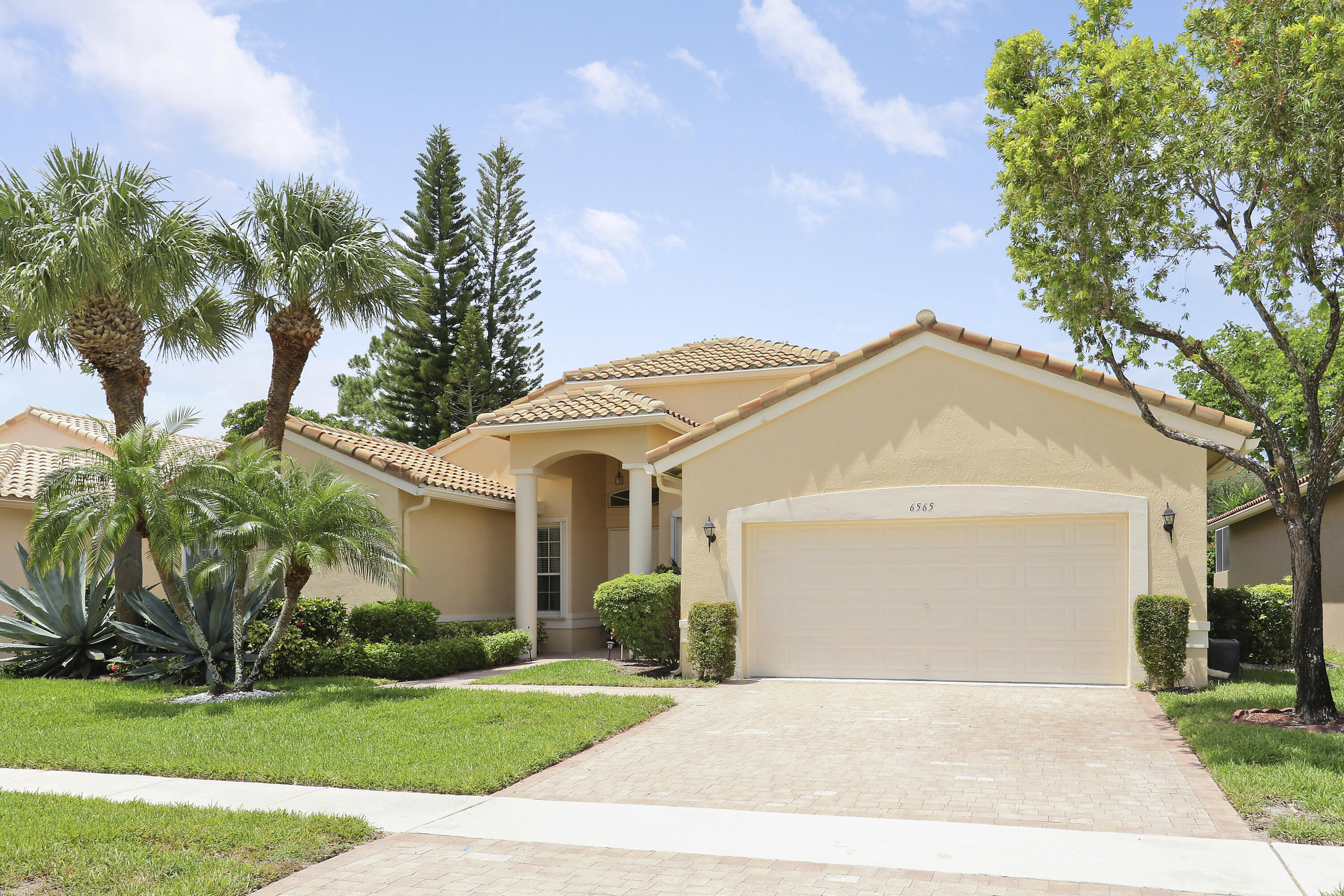 6565 Garde Road Boynton Beach, FL 33472 - Photo 2 of 54 a view of white house with a yard and potted plants