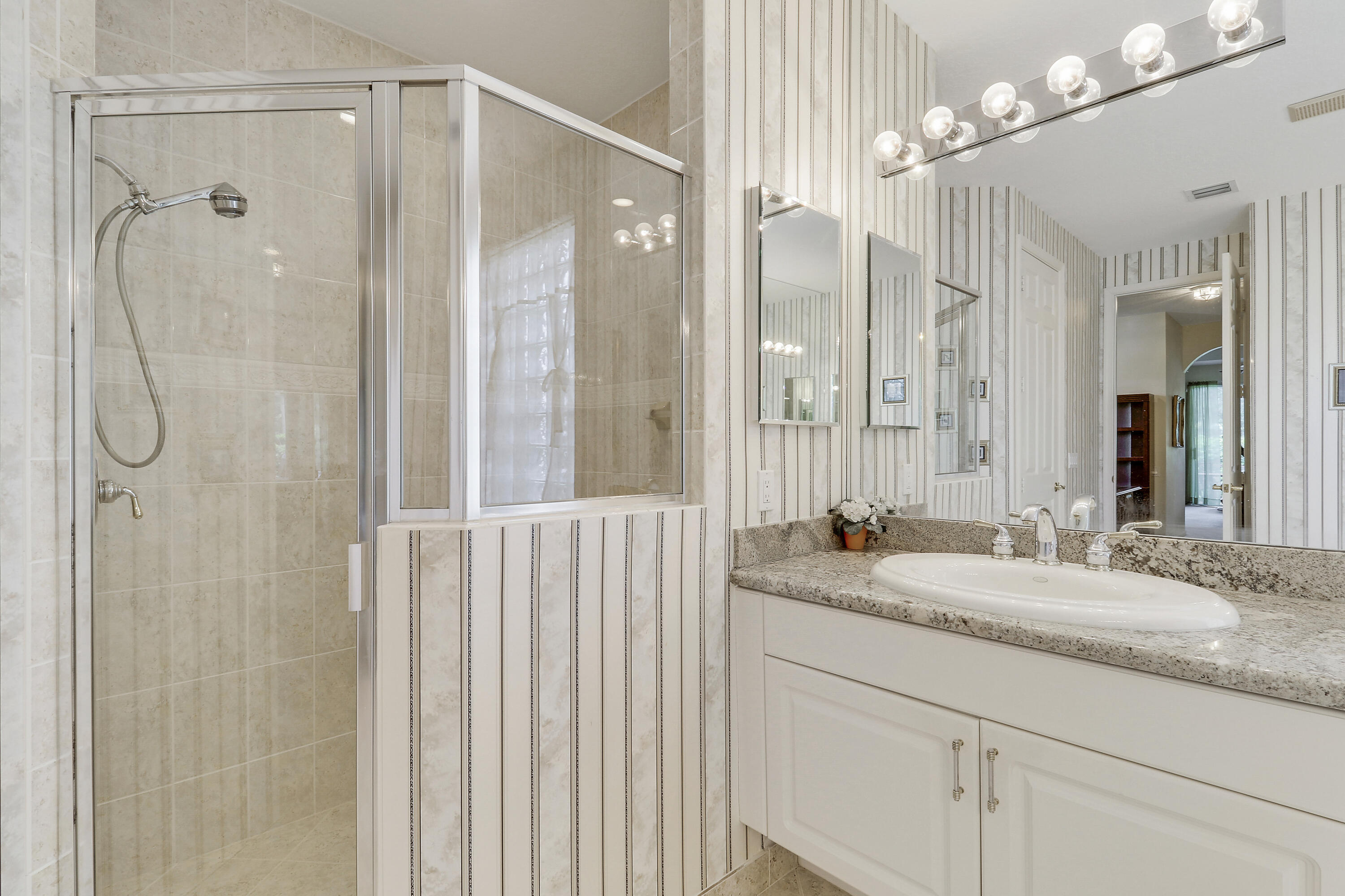 6565 Garde Road Boynton Beach, FL 33472 - Photo 32 of 54 a bathroom with a granite countertop sink a mirror and a shower