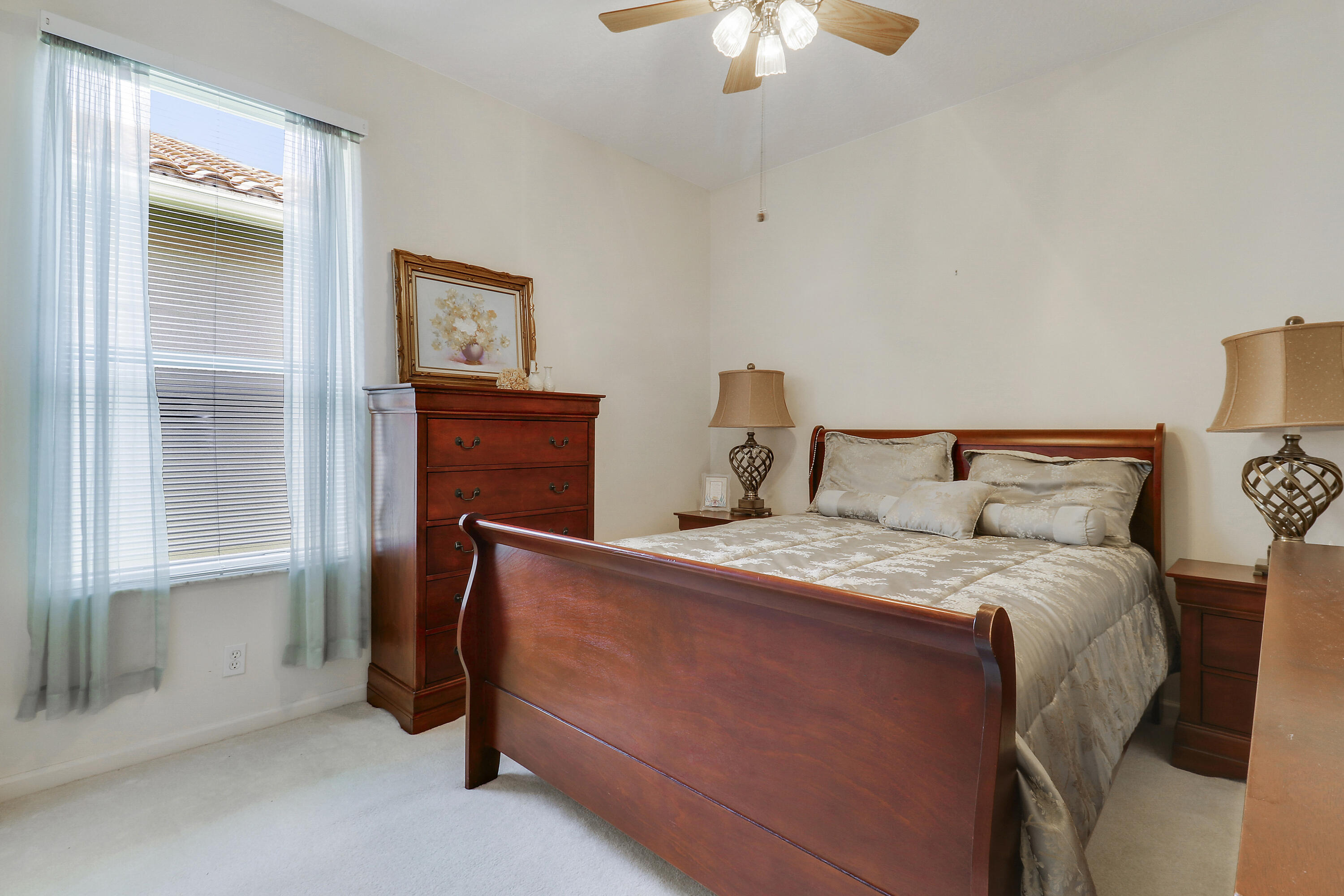6565 Garde Road Boynton Beach, FL 33472 - Photo 35 of 54 a bedroom with a bed and a chandelier