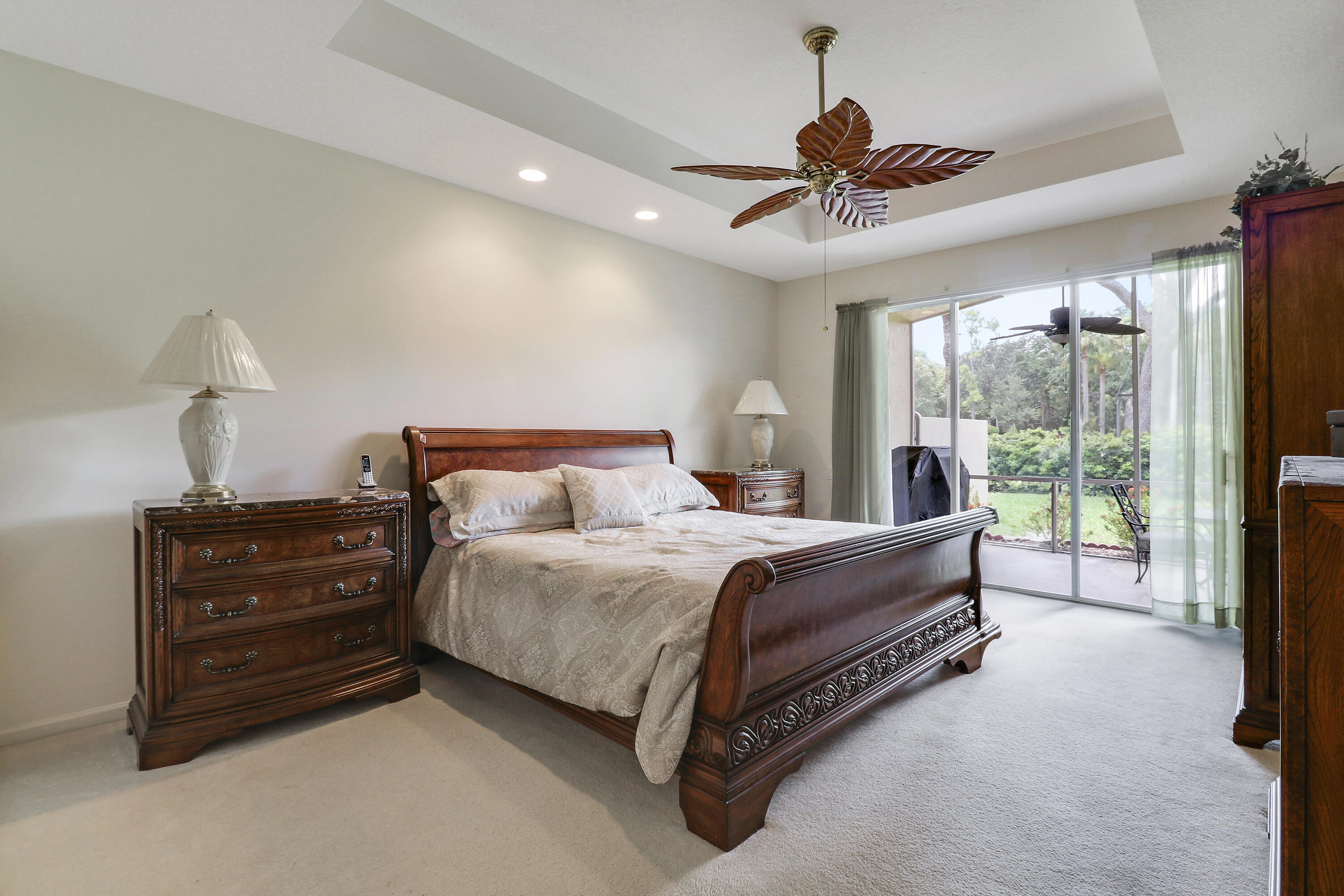 6565 Garde Road Boynton Beach, FL 33472 - Photo 9 of 54 a spacious bedroom with a bed and a chandelier
