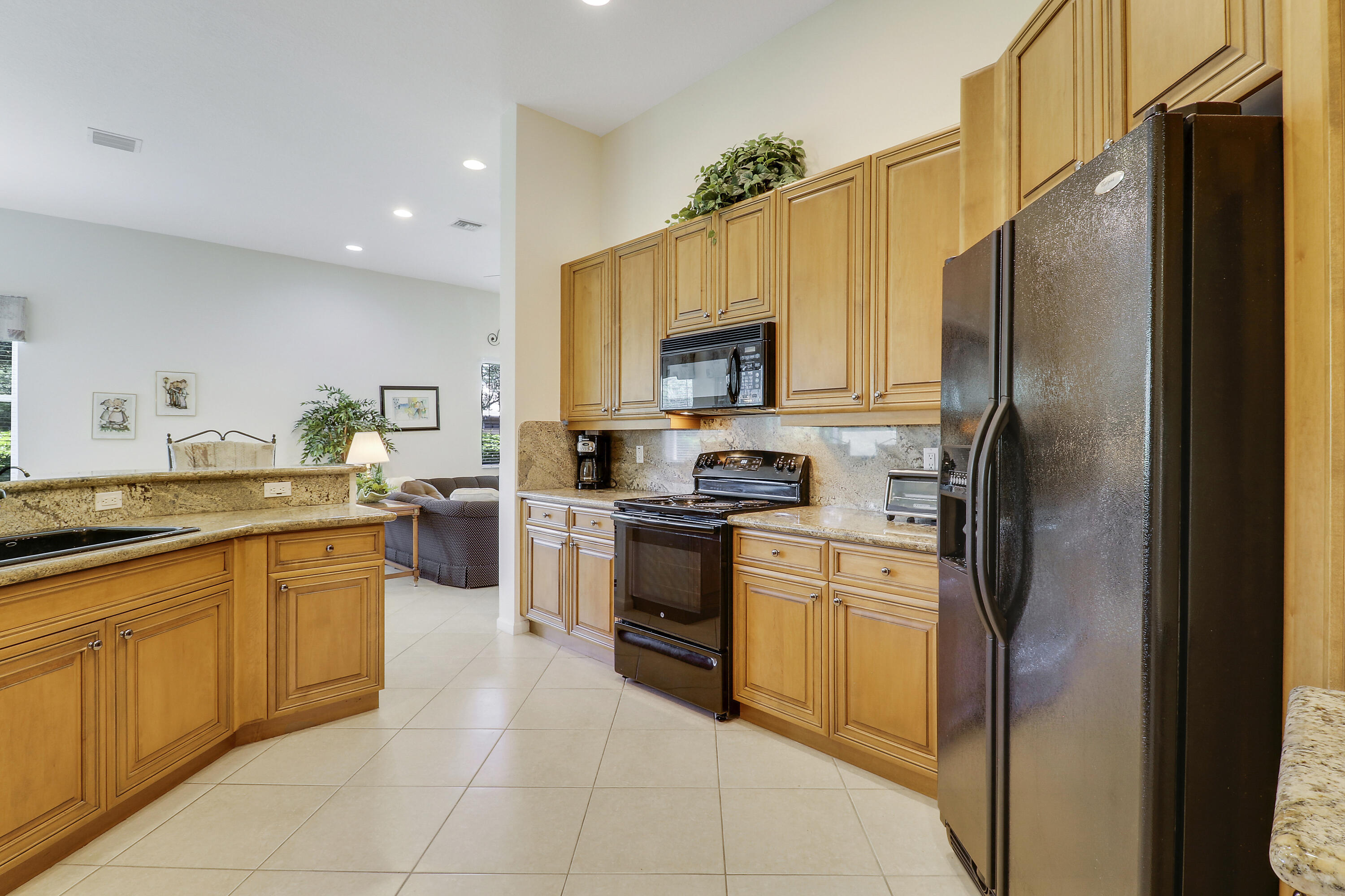 6565 Garde Road Boynton Beach, FL 33472 - Photo 10 of 54 a kitchen with stainless steel appliances granite countertop a refrigerator and a stove top oven