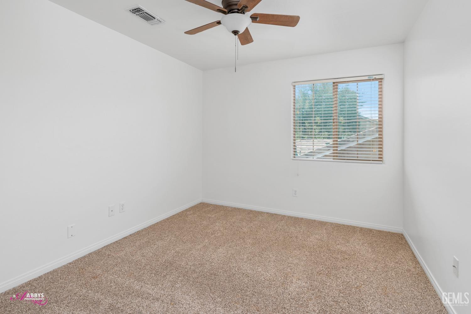 Undisclosed Address Bakersfield, CA 93312 - Photo 14 of 44 an empty room with a ceiling fan and windows