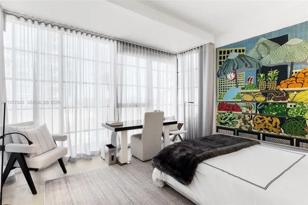 a bedroom with a bed a couch and a potted plant