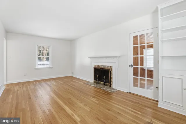an empty room with wooden floor and fireplace