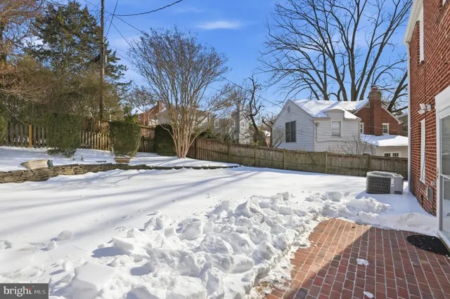 a view of a backyard with snow on the road