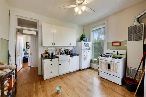a kitchen with cabinets a wooden floor and a fireplace