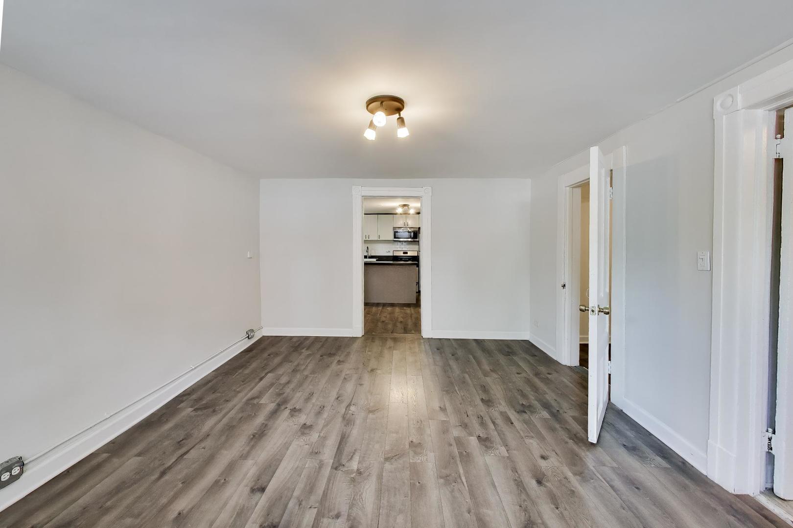 2701 West Haddon Avenue Chicago, IL 60622 - Photo 18 of 22 an empty room with wooden floor and windows