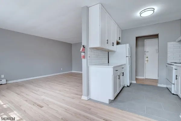 a kitchen with cabinets and wooden floor
