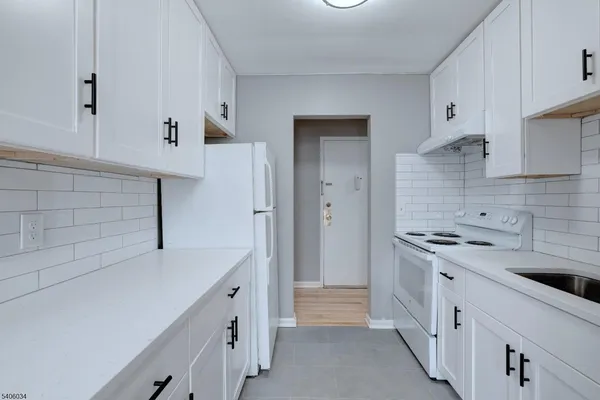 a kitchen with cabinets and white appliances