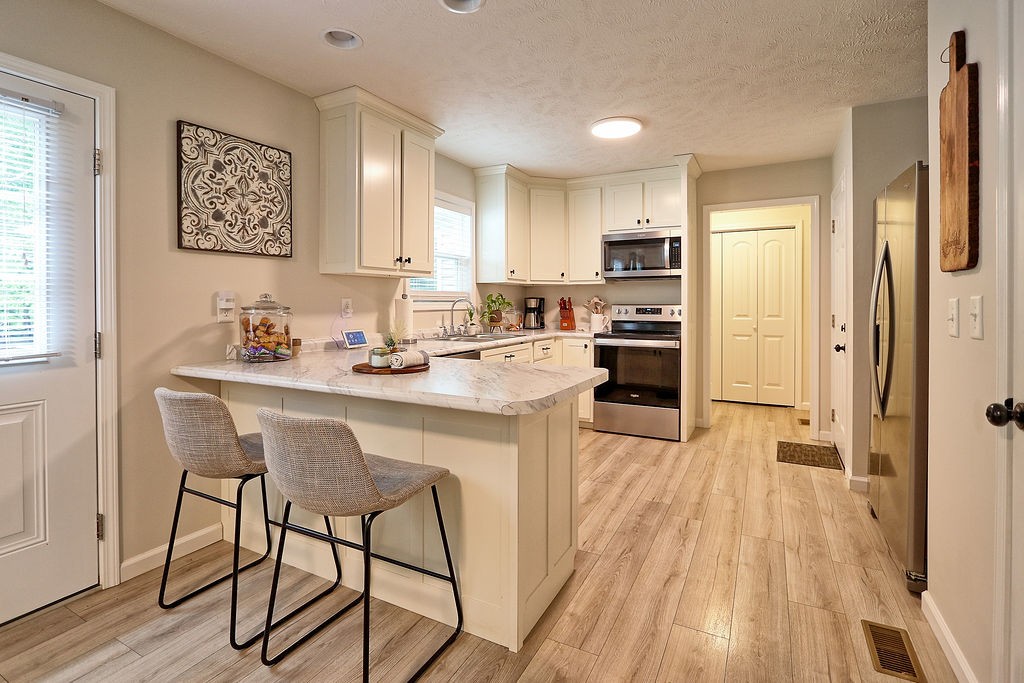 111 Heritage Hills Lane Hohenwald, TN 38462 - Photo 13 of 48 a kitchen with a table chairs refrigerator and cabinets