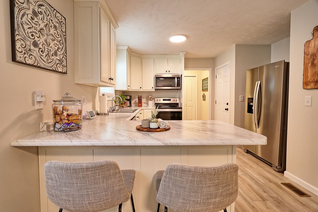 111 Heritage Hills Lane Hohenwald, TN 38462 - Photo 14 of 48 a kitchen with stainless steel appliances granite countertop a sink refrigerator and microwave