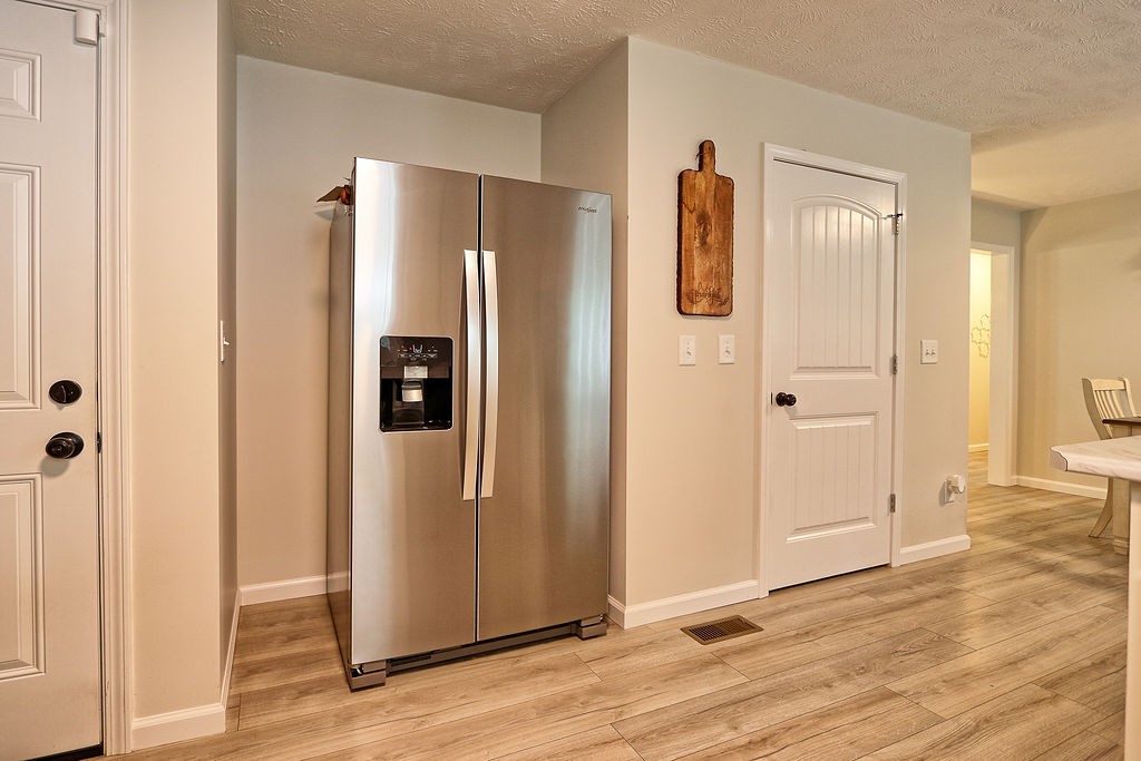 111 Heritage Hills Lane Hohenwald, TN 38462 - Photo 20 of 48 a view of a hallway with wooden floor and refrigerator