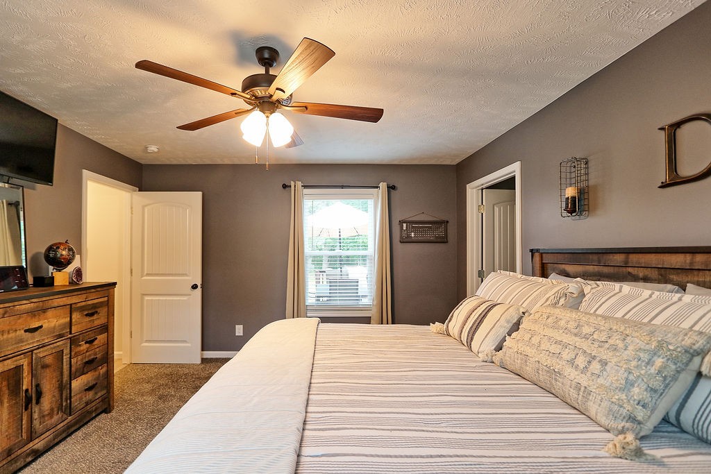 111 Heritage Hills Lane Hohenwald, TN 38462 - Photo 27 of 48 a bedroom with a bed and a chandelier