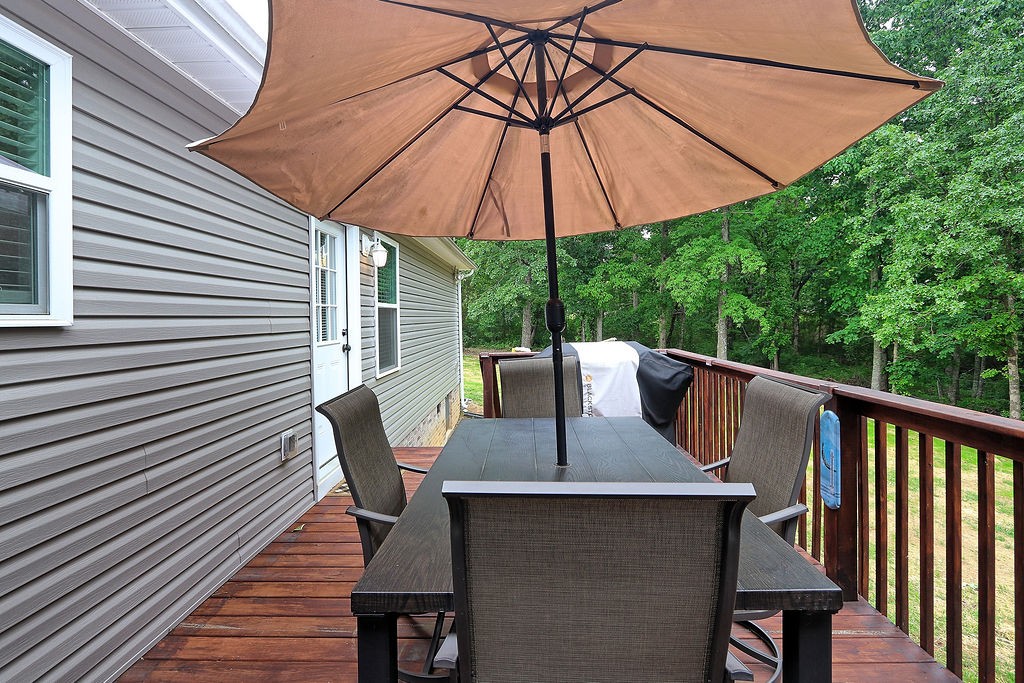 111 Heritage Hills Lane Hohenwald, TN 38462 - Photo 38 of 48 a roof deck with a table and chairs under an umbrella