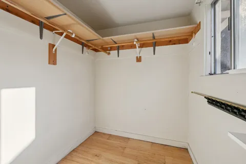 a view of walk in closet with empty racks