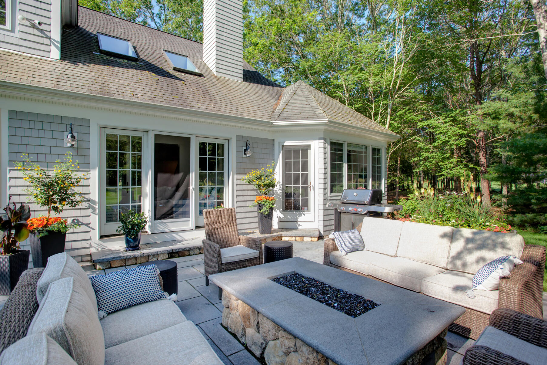 101 Reflection Drive Sandwich, MA 02563 - Photo 31 of 37 a view of a patio with couches table and chairs with potted plants and large tree