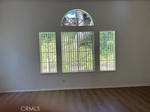 an empty room with wooden floor a chandelier