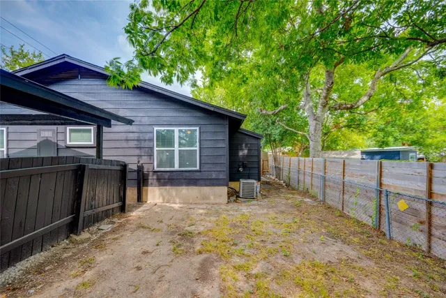 a view of backyard with wooden fence and a large tree