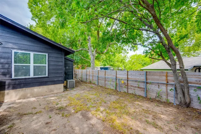 a view of a backyard with wooden fence