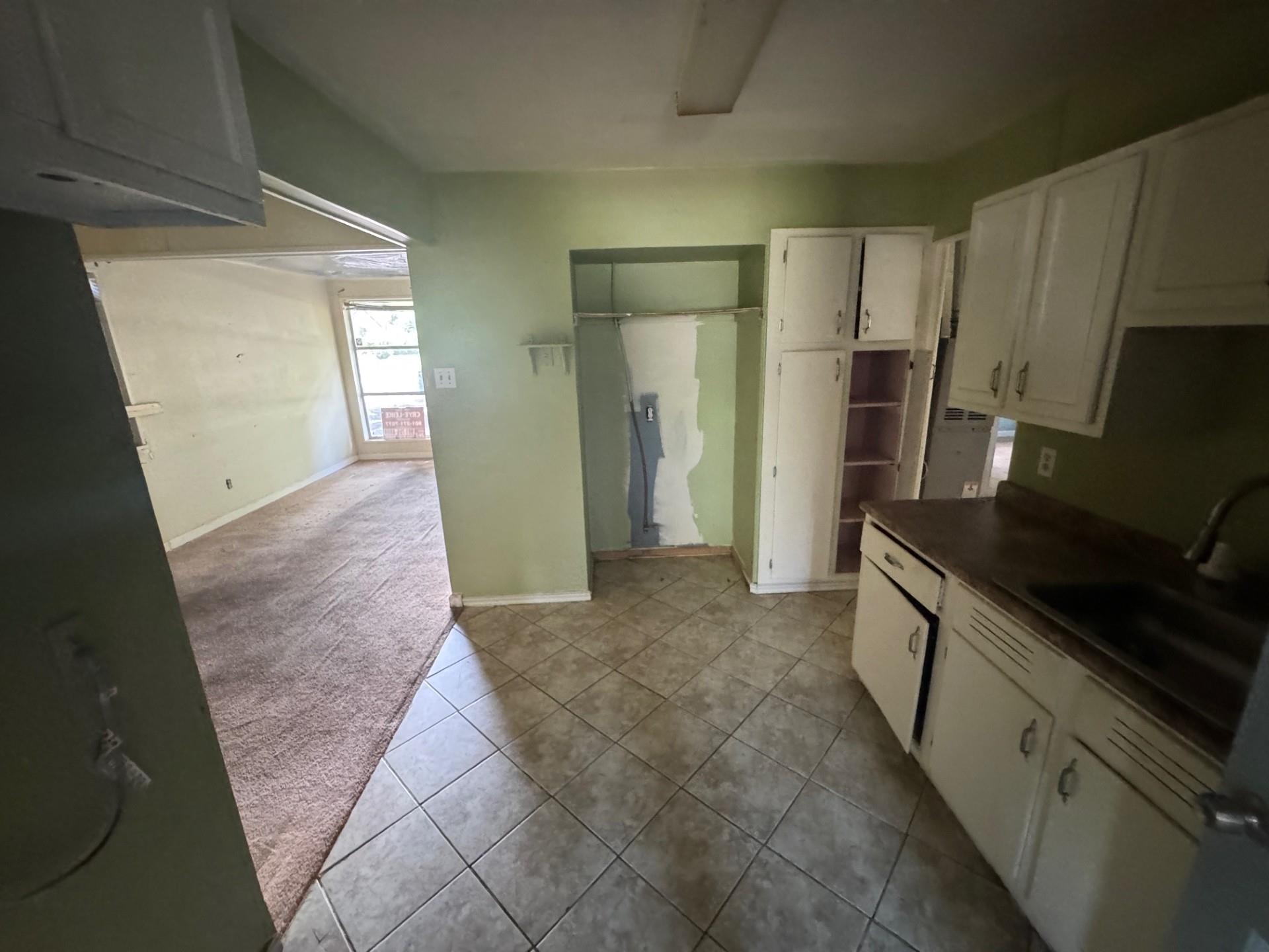 994 North Perkins Road Memphis, TN 38122 - Photo 5 of 15 Kitchen with white cabinets, dark countertops, carpet flooring, and tile patterned floors