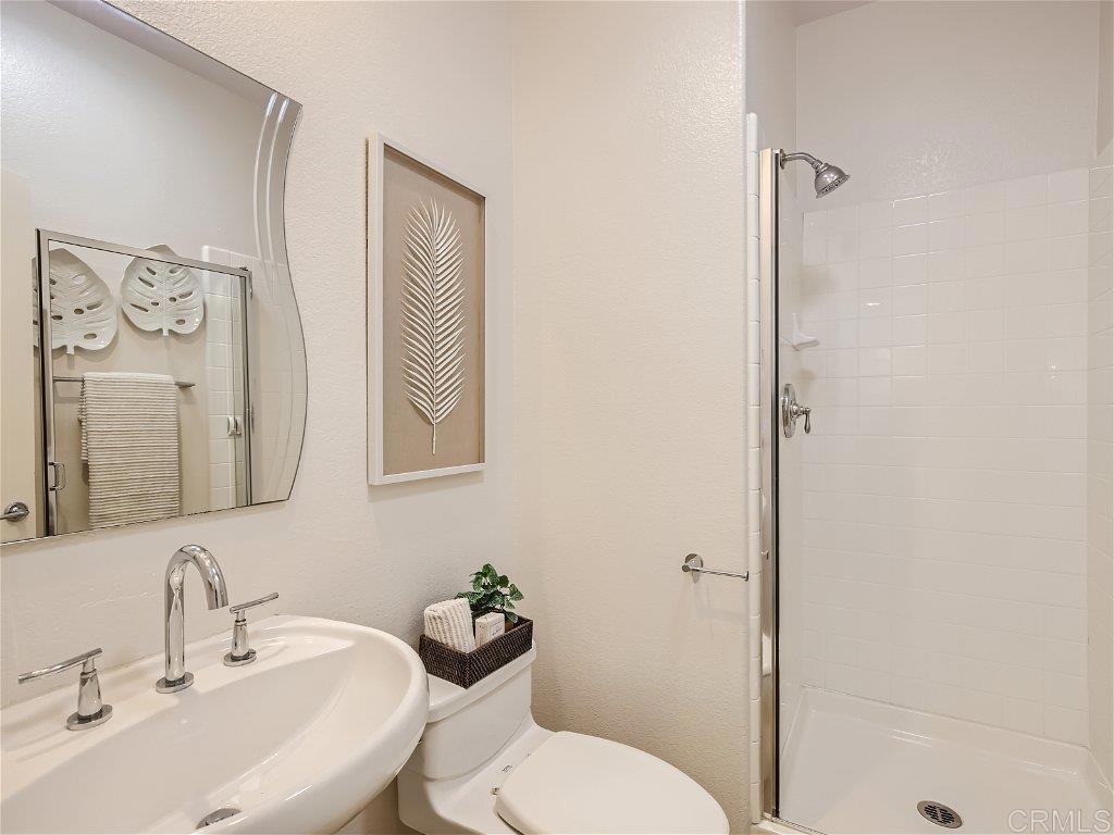 6562 Windflower Drive Carlsbad, CA 92011 - Photo 13 of 28 a bathroom with a toilet sink and mirror