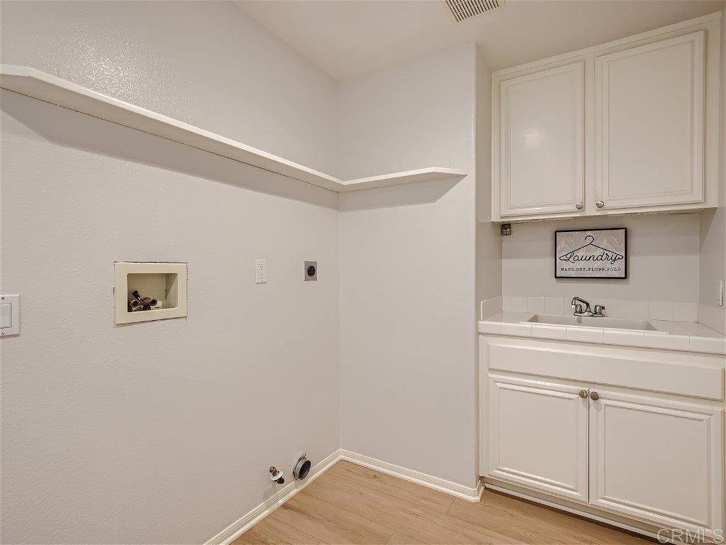 6562 Windflower Drive Carlsbad, CA 92011 - Photo 23 of 28 a view of cabinets with wooden floor