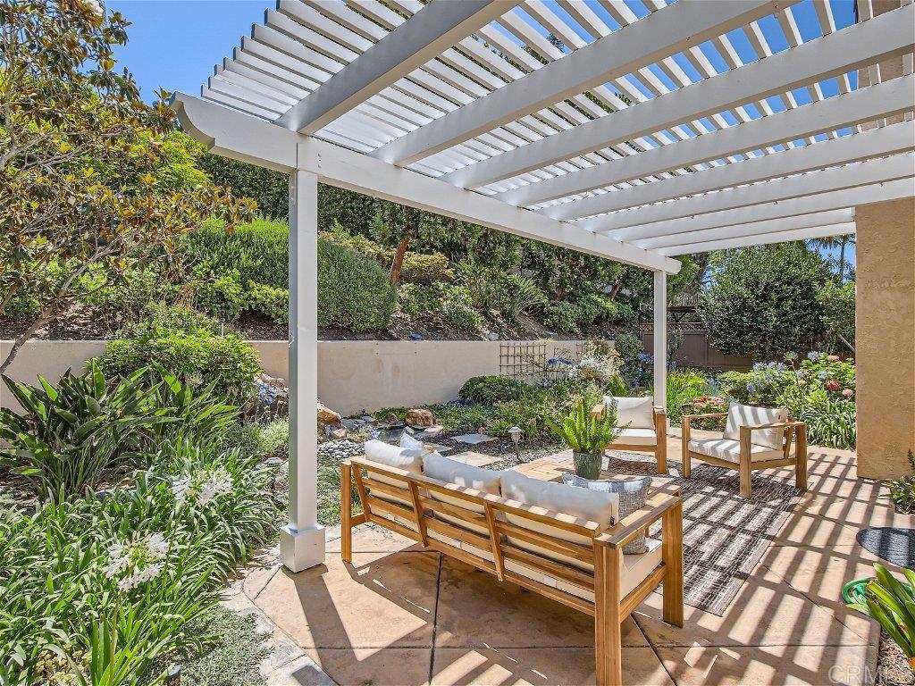6562 Windflower Drive Carlsbad, CA 92011 - Photo 24 of 28 a view of a patio with table and chairs potted plants and floor to ceiling window