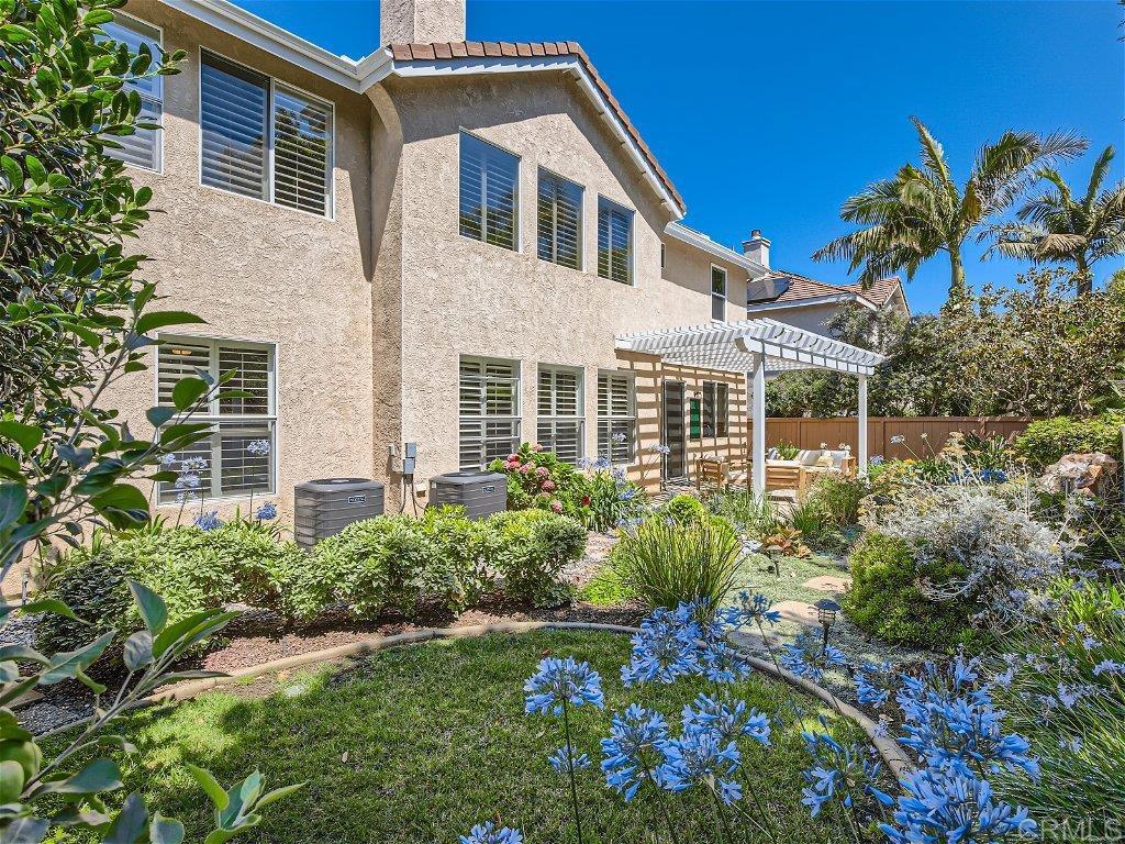 6562 Windflower Drive Carlsbad, CA 92011 - Photo 26 of 28 a house that has a lot of flower plants in front of main door