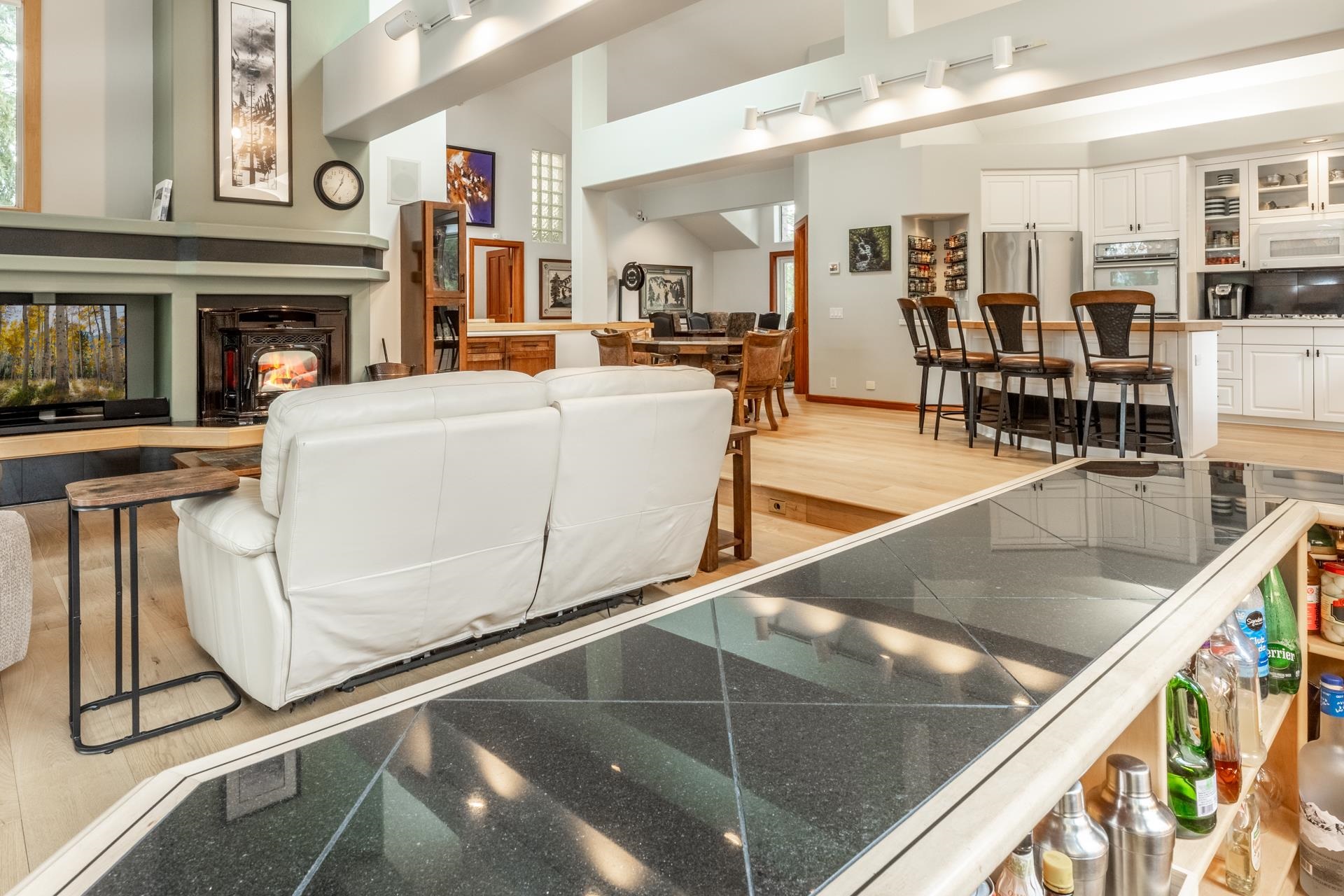 244 Ridge Way Mammoth Lakes, CA 93546 - Photo 14 of 49 Living room featuring track lighting, light wood finished floors, a multi sided fireplace, and a high ceiling