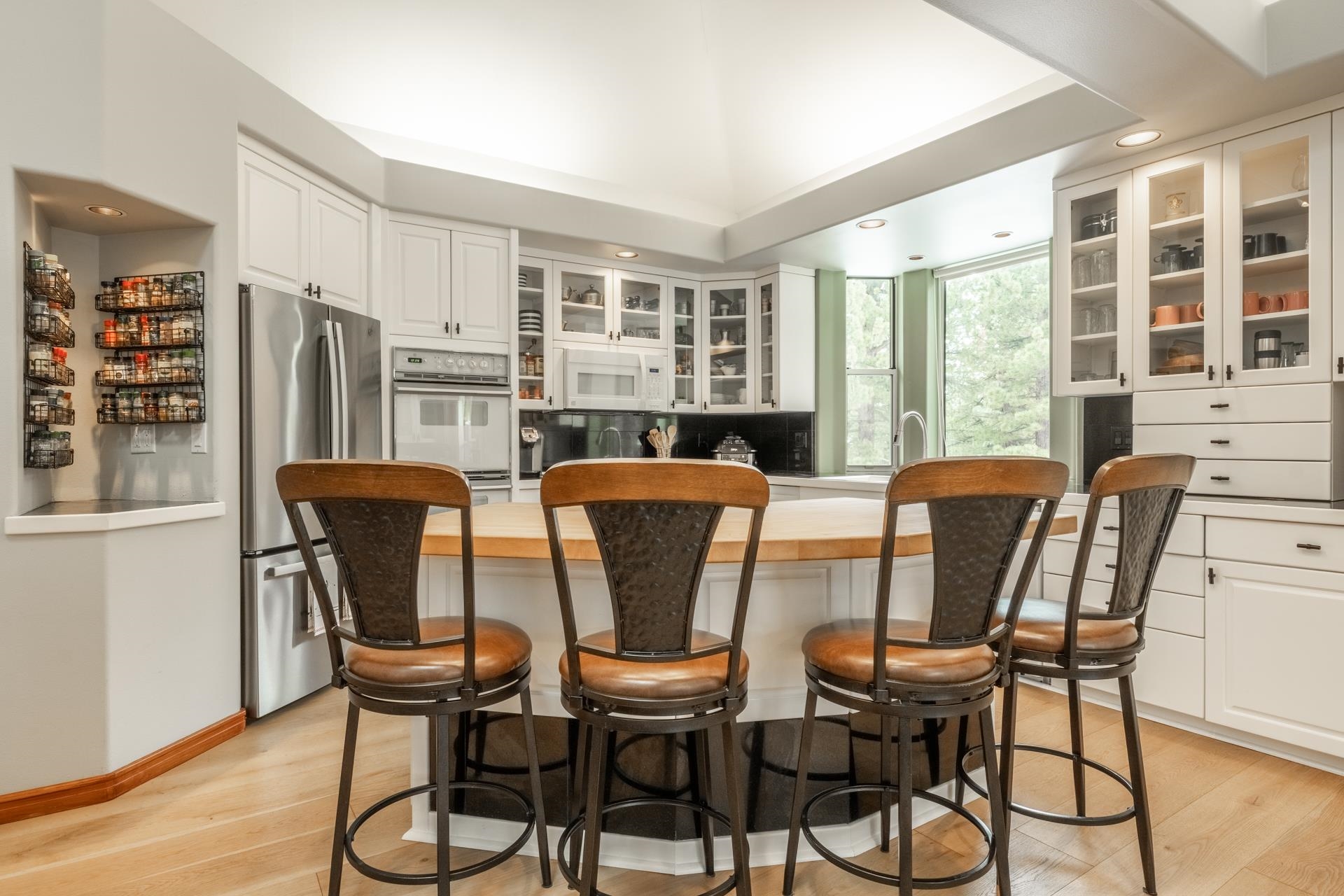 244 Ridge Way Mammoth Lakes, CA 93546 - Photo 17 of 49 Kitchen with a kitchen island, a kitchen bar, glass fronted cabinets, white appliances, and white cabinetry