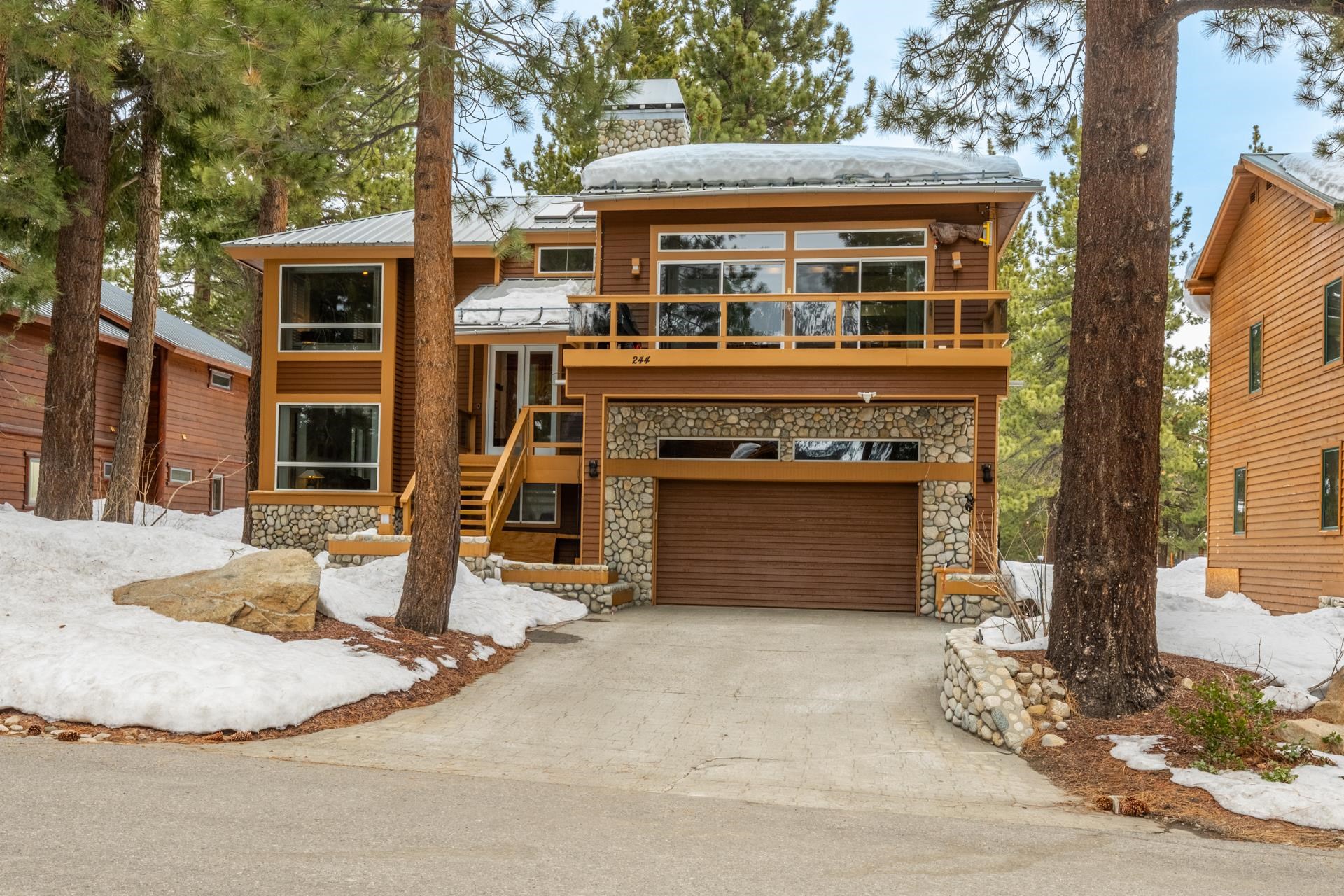 244 Ridge Way Mammoth Lakes, CA 93546 - Photo 3 of 49 View of front of house featuring stone siding, a garage, driveway, and a chimney