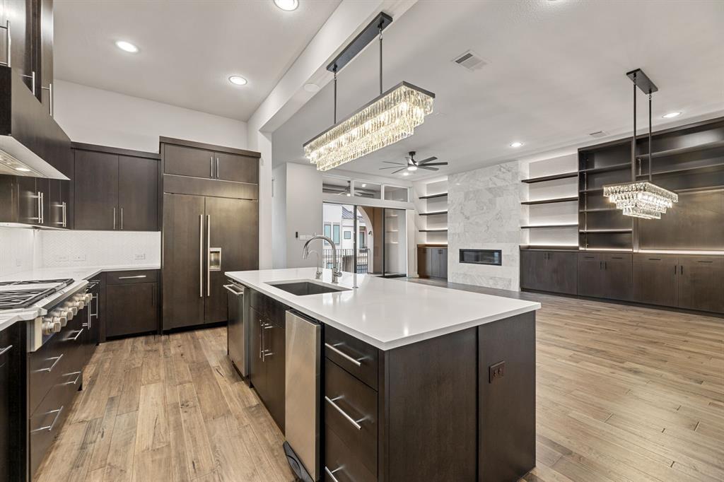7854 Element Avenue Plano, TX 75024 - Photo 22 of 38 Kitchen with a chandelier, dark brown cabinets, light wood-style flooring, pendant lighting, and recessed lighting