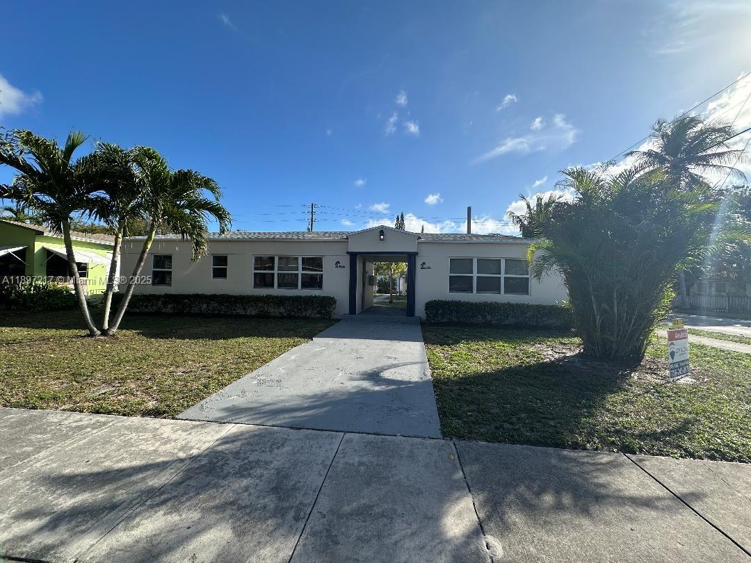 1956 Lincoln Street, Unit 10 Hollywood, FL 33020 - Photo 2 of 9 a view of a house with a yard and potted plants
