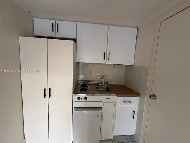 a kitchen with appliances a sink and cabinets