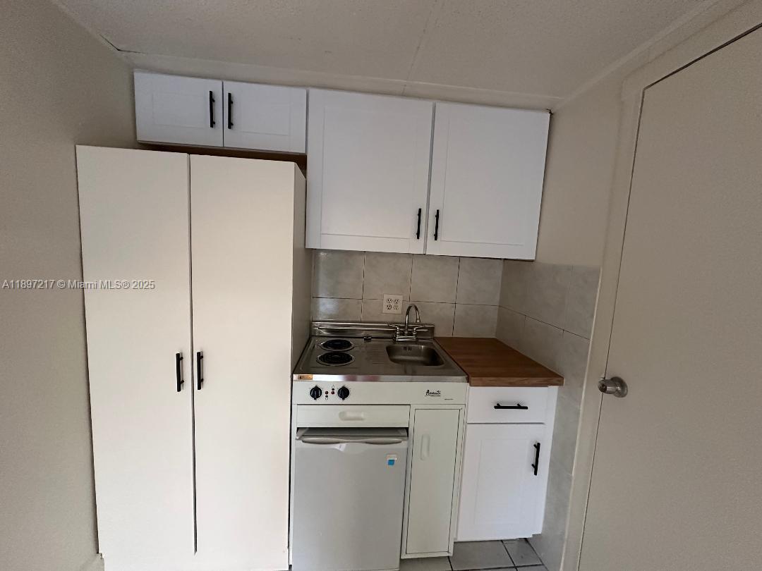 1956 Lincoln Street, Unit 10 Hollywood, FL 33020 - Photo 4 of 9 a kitchen with appliances a sink and cabinets
