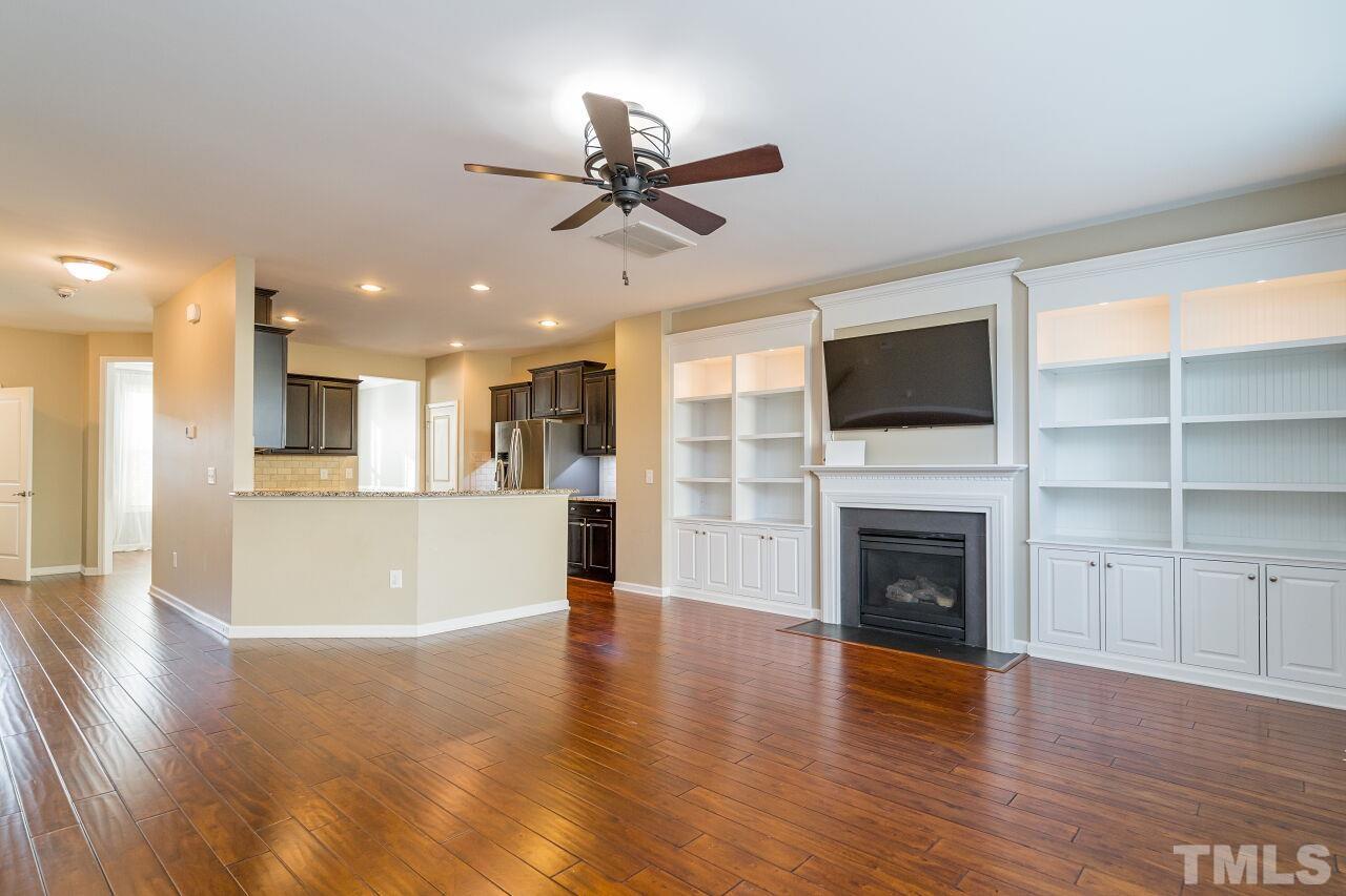 1323 Rodessa Run Raleigh, NC 27607 - Photo 11 of 29 a view of a livingroom with a fireplace a ceiling fan and windows