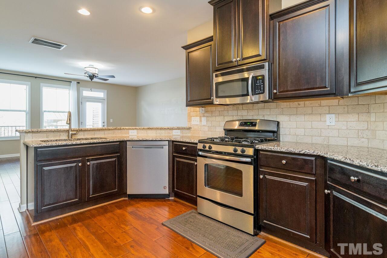 1323 Rodessa Run Raleigh, NC 27607 - Photo 16 of 29 a kitchen with stainless steel appliances granite countertop a stove microwave and sink