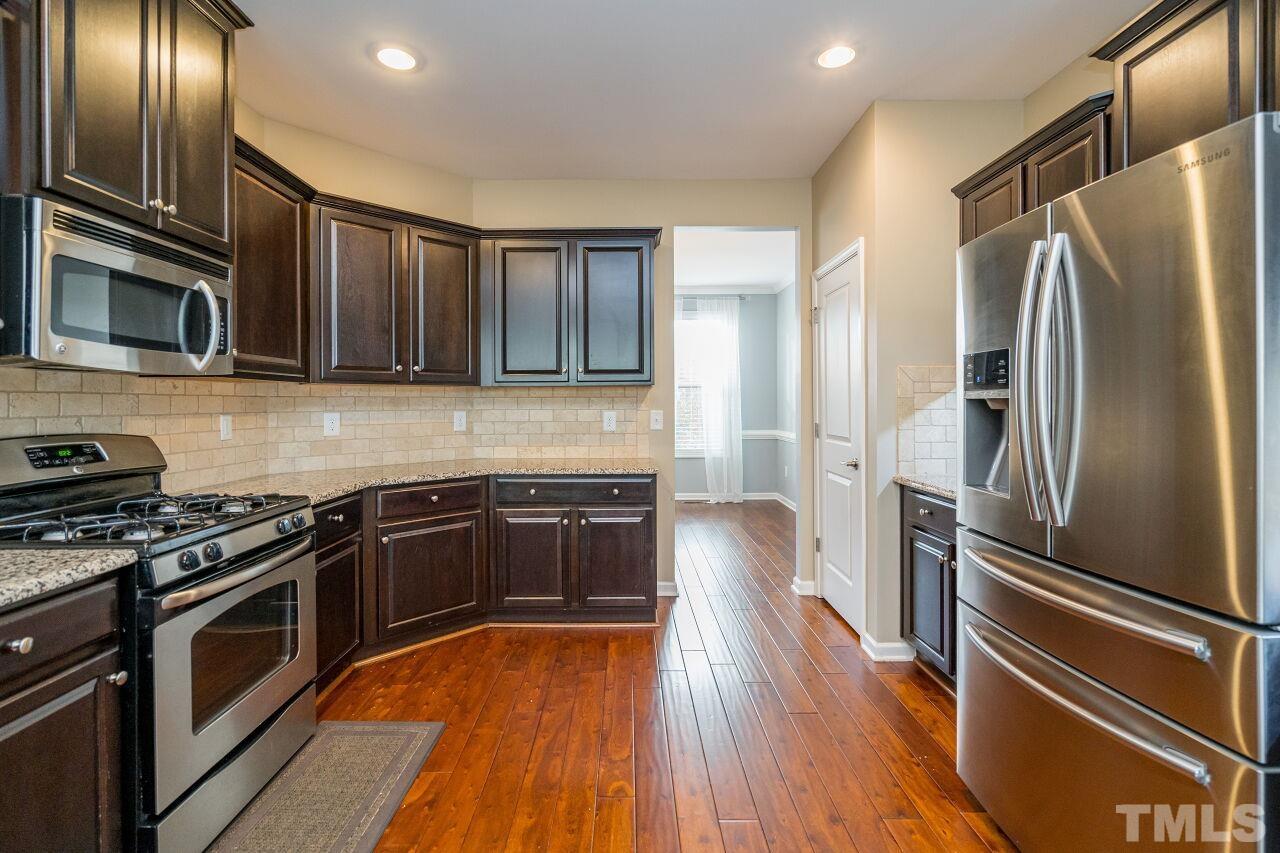 1323 Rodessa Run Raleigh, NC 27607 - Photo 18 of 29 a kitchen with granite countertop stainless steel appliances and wooden cabinets