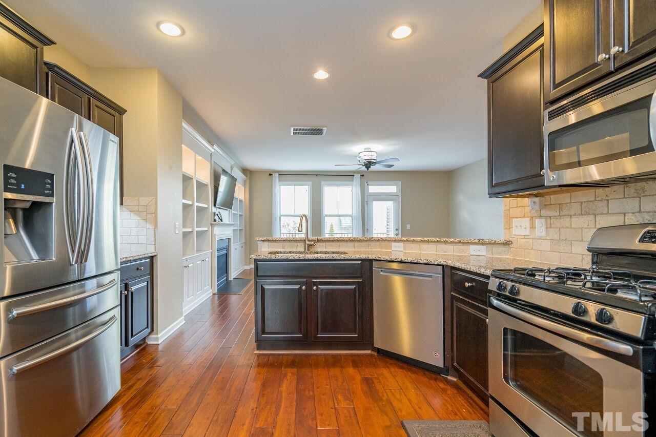 1323 Rodessa Run Raleigh, NC 27607 - Photo 19 of 29 a kitchen with stainless steel appliances granite countertop a stove and a sink