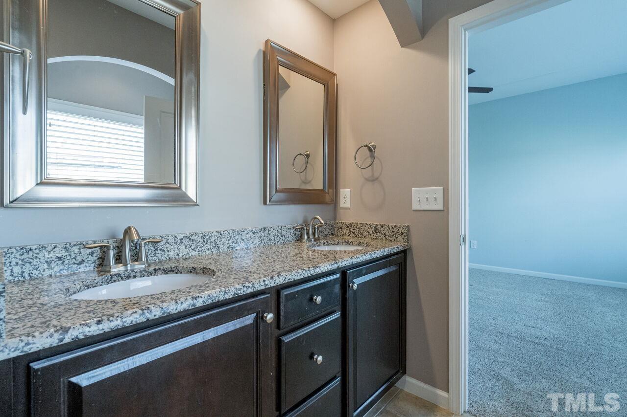 1323 Rodessa Run Raleigh, NC 27607 - Photo 24 of 29 a bathroom with a granite countertop sink and a mirror