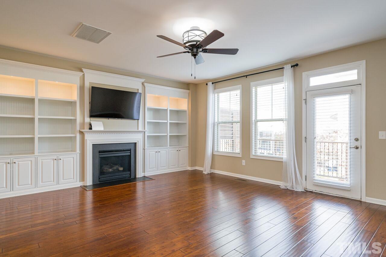 1323 Rodessa Run Raleigh, NC 27607 - Photo 8 of 29 wooden floor fireplace and windows in an empty room