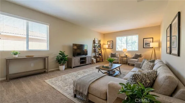 a living room with furniture a flat screen tv and a large window